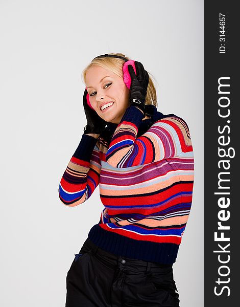 A blond girl wearing winter clothing and ear muffs smile, stripe colours. A blond girl wearing winter clothing and ear muffs smile, stripe colours