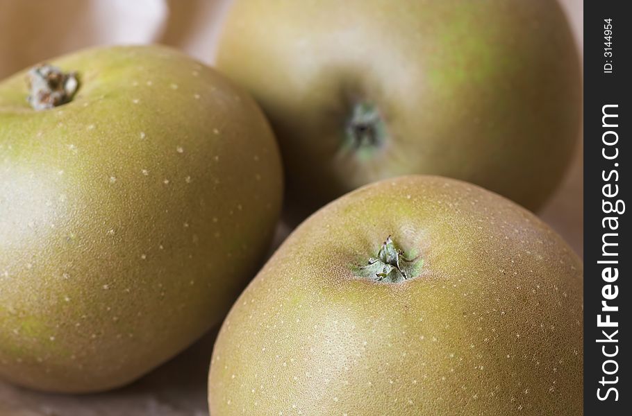 A group of golden - rough-skinned - russet apples.