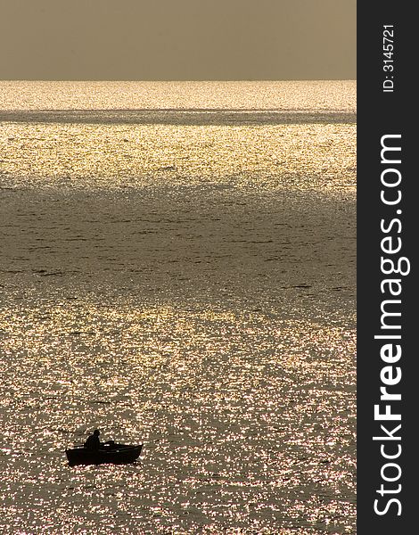 Alone fisherman in the boat, a lot of glare. Alone fisherman in the boat, a lot of glare