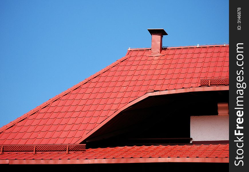 Red roof with a chimney under a blue sky