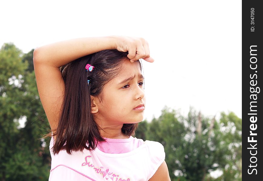 A portrait of a young girl posing with her hand on her head.