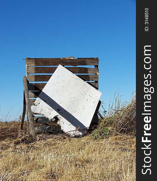 A blank collapsing shooting target board in a field.