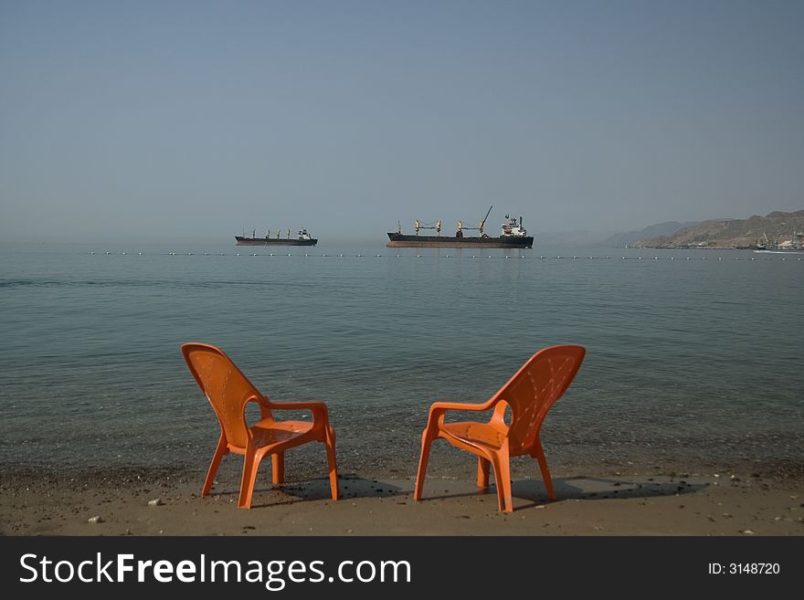 Two boats and two seats on the beach