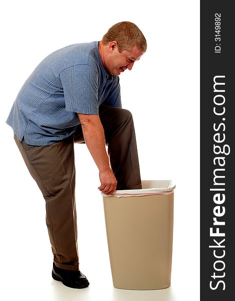 A man pushing his foot into the trash can to compact the trash. isolated on white. A man pushing his foot into the trash can to compact the trash. isolated on white.