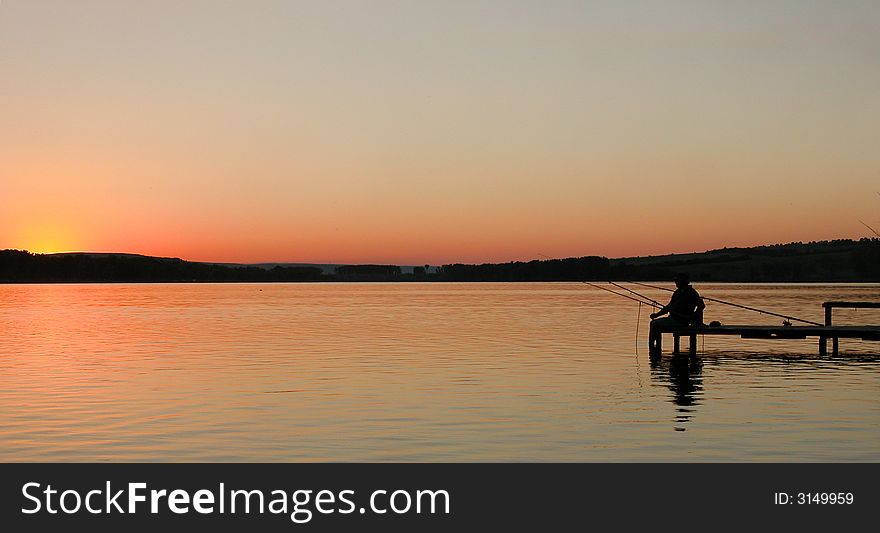 Man fishing from bridge on the lake in sunset. Man fishing from bridge on the lake in sunset