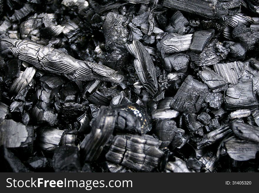 Black smoldering wood embers for background