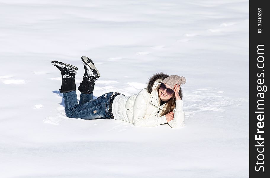 Young woman enjoying winter and playing with snow outdoor