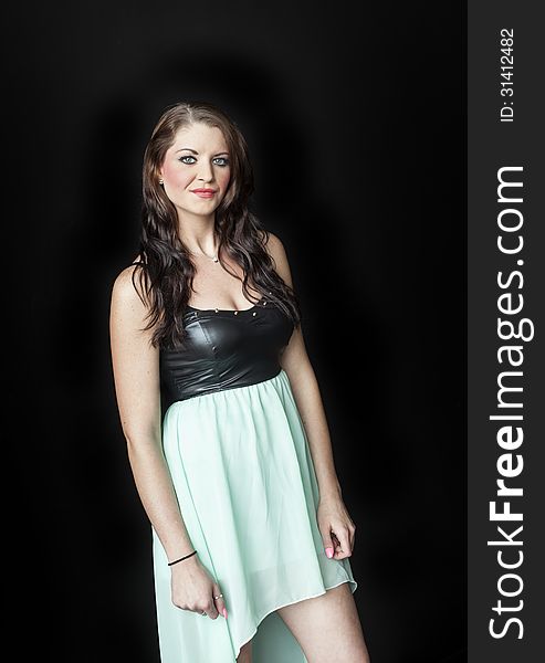 Portrait of a beautiful young woman with brown hair and blue eyes shot on a black background. Portrait of a beautiful young woman with brown hair and blue eyes shot on a black background.