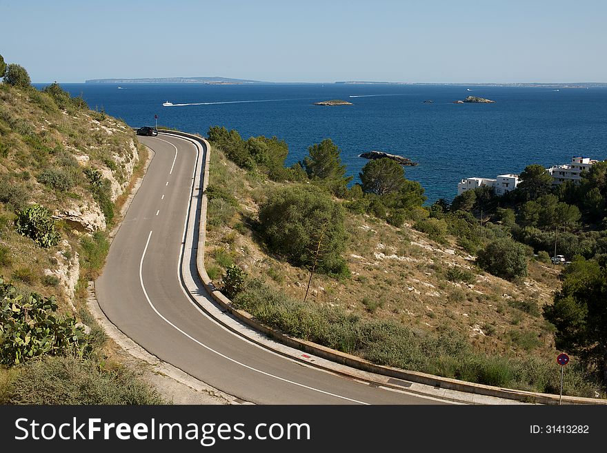 Picture of road turns, with a beautiful sea view and islands in the background