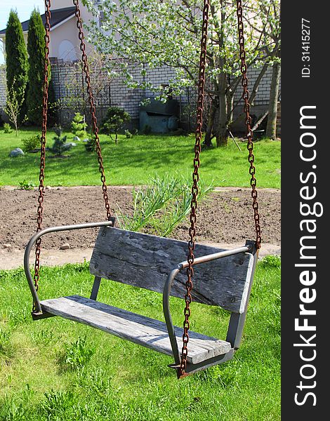 Old wood swing in the garden in spring