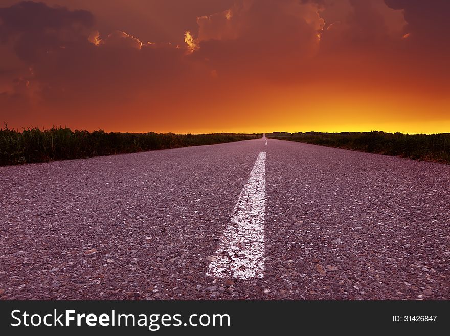 Driving on an empty road at beautiful sunset