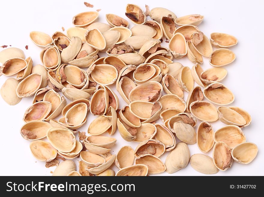 Many pistachio shells close-up on a white background