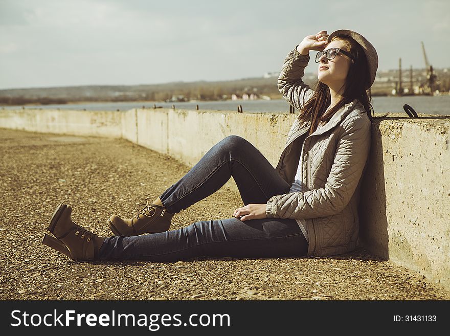 Teenager in sitting on sidewalk