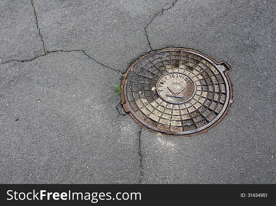 Sewer manhole cover on asphalt. Sewer manhole cover on asphalt