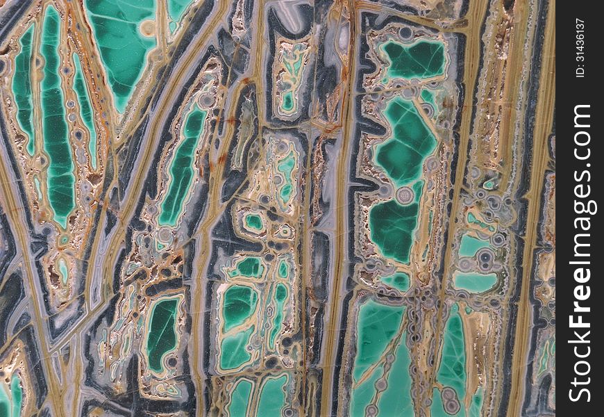 Colorful multi-colored smooth face of a cut rock called variscite. Suitable for a background. Colorful multi-colored smooth face of a cut rock called variscite. Suitable for a background.