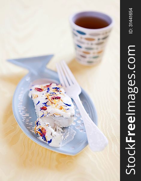 Baked cod with horseradish sauce and dried flower petals, selective focus