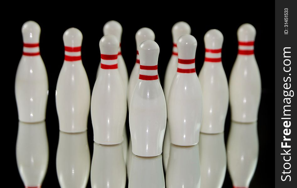 Ten bowling pins isolated on black background