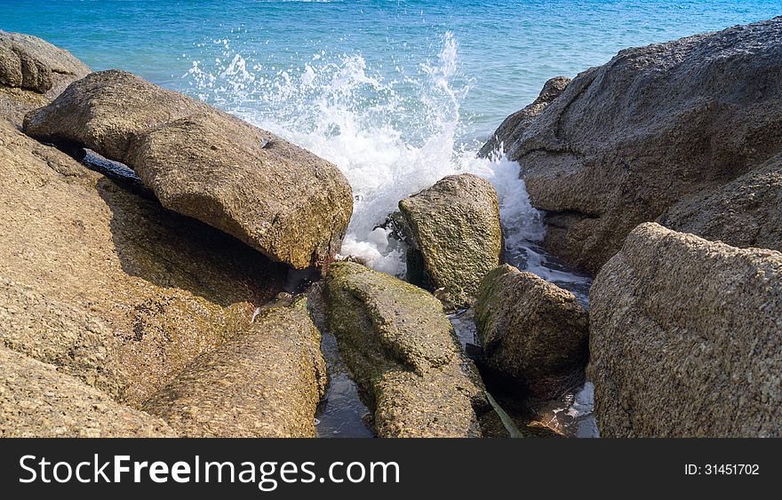 The waves break on the huge rocks. The waves break on the huge rocks