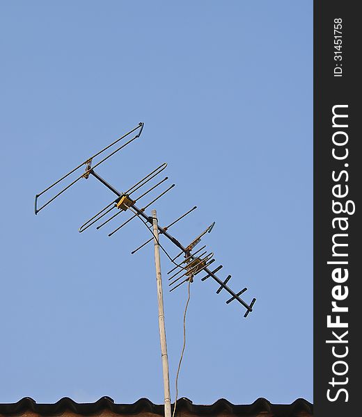 Television antenna on bamboo pole in blue sky. Television antenna on bamboo pole in blue sky