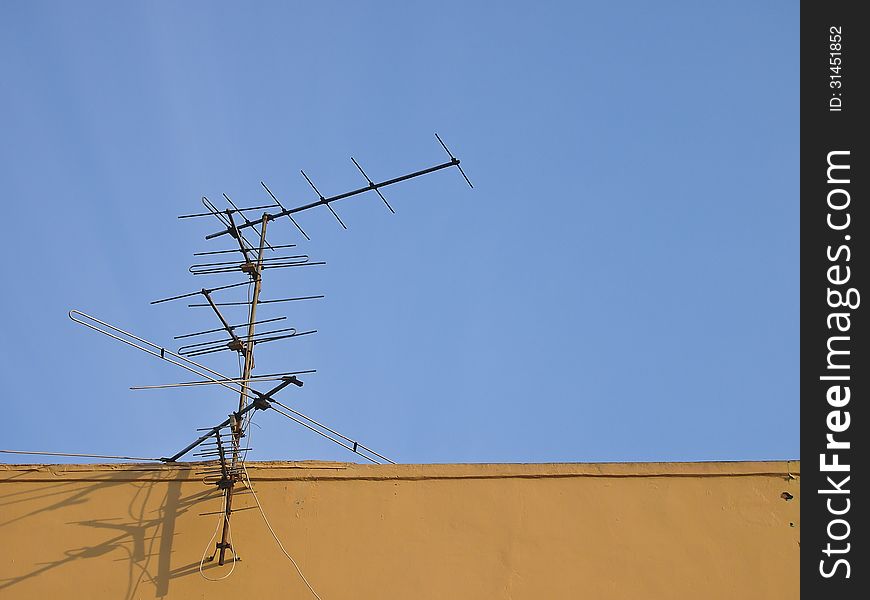 Receive antenna on top roof in blue sky. Receive antenna on top roof in blue sky