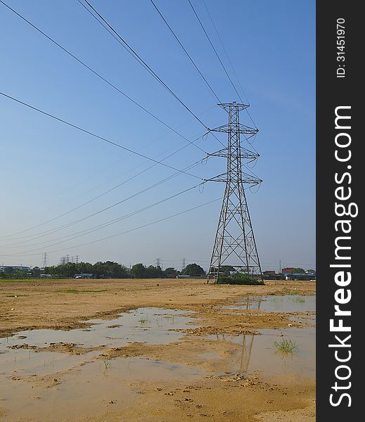 High voltage tower in wet land and blue sky