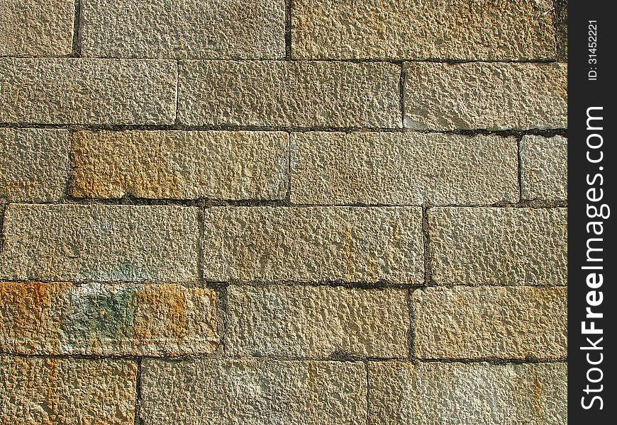 Surface of big stone wall in sunlight
