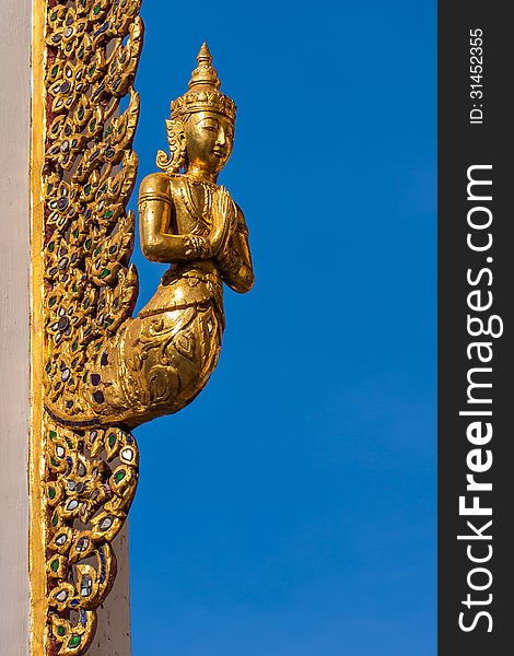 Angel sculpture at gate of buddhist church in Bangkok