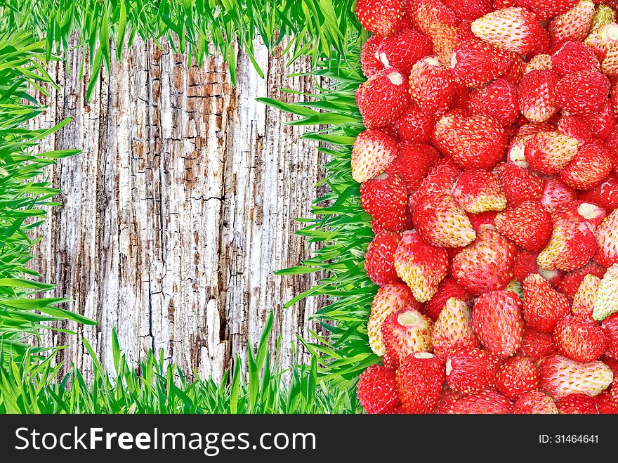 Frame of strawberries and grass and wooden background.