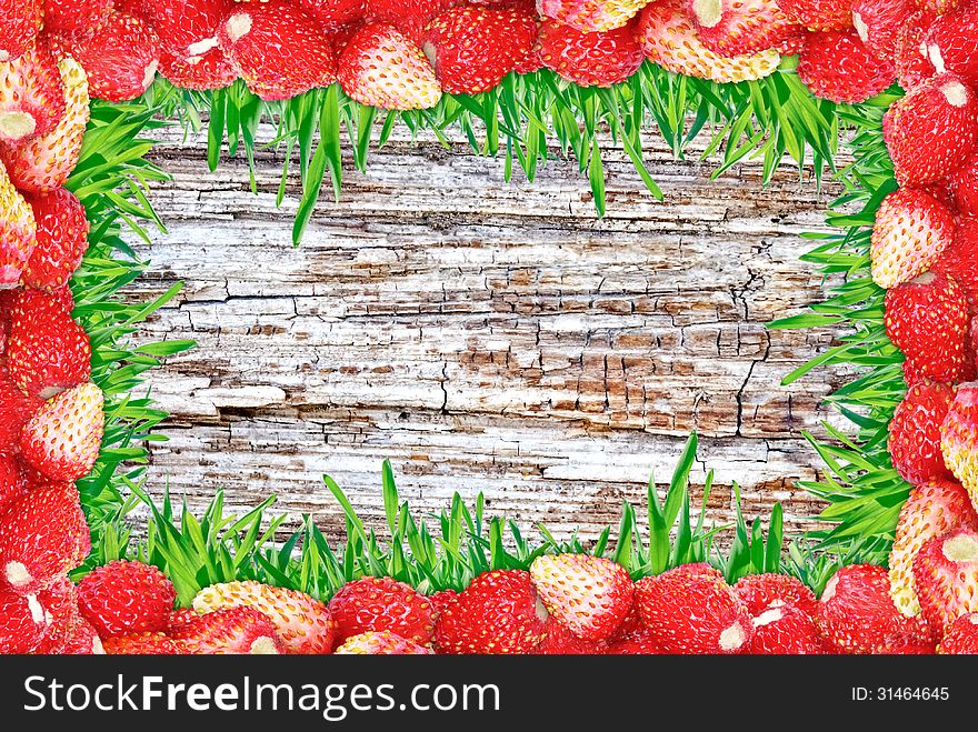 Frame Of Strawberries And Grass And Wooden Background.