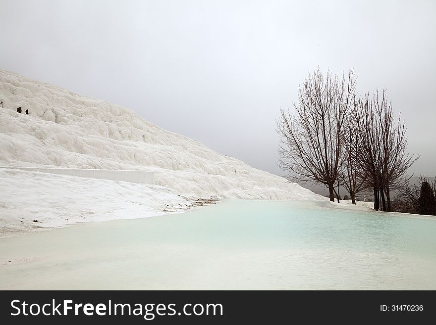 Travertines with blue water in Pamukkale, Turkey