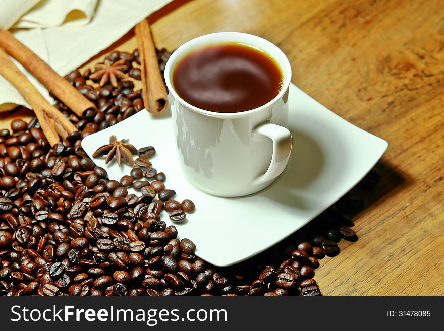 Hot coffee with beans and herbal background