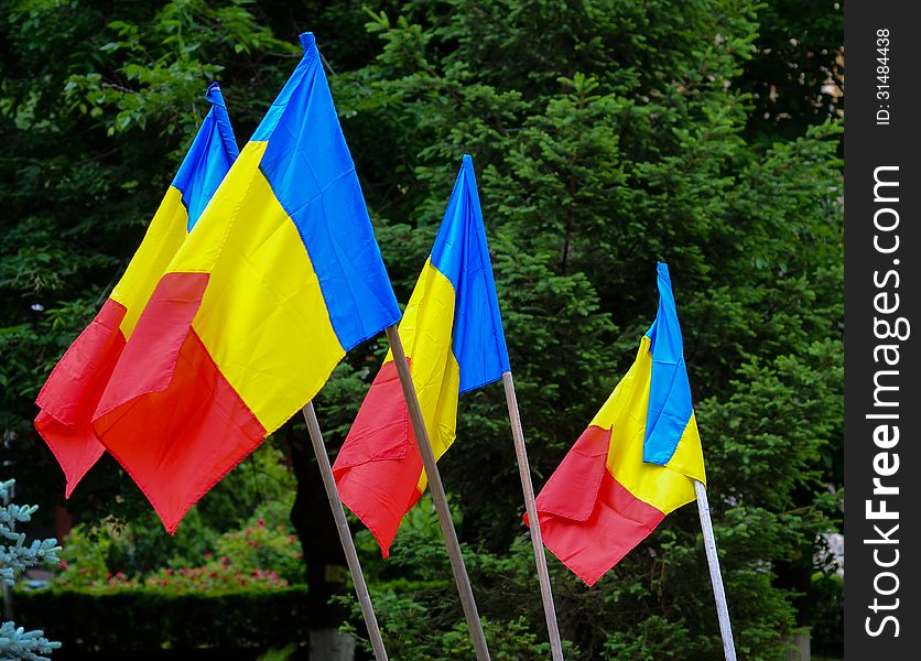 Romanian flags against green trees