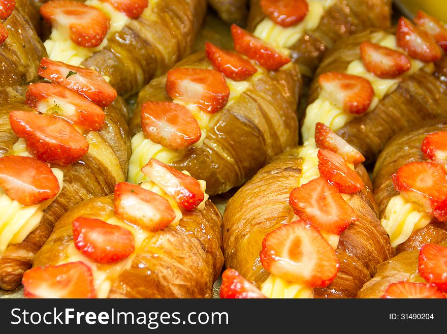 Image of delicious croissants filled with cream and covered with layers of strawberry. Image of delicious croissants filled with cream and covered with layers of strawberry.