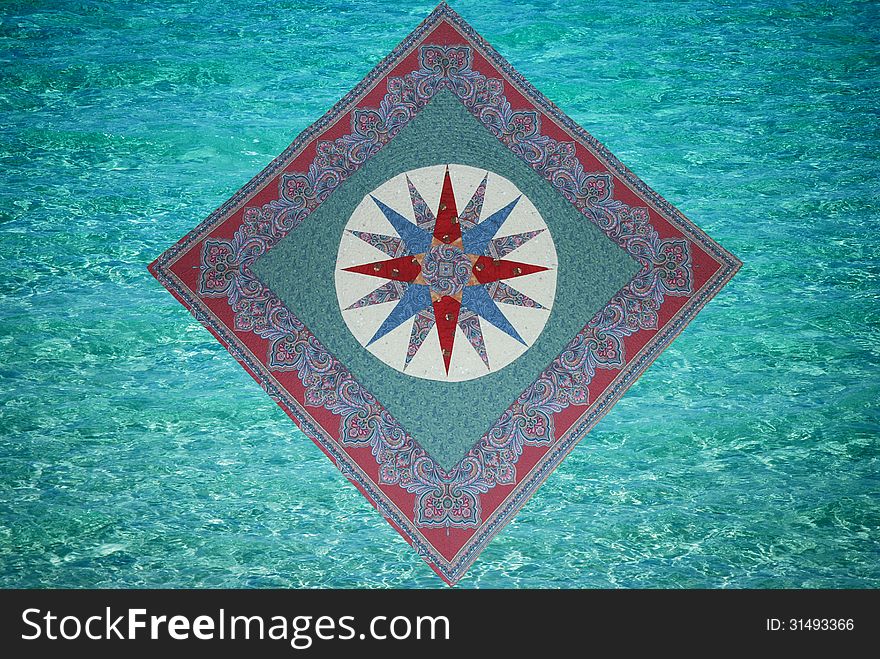 A quilt wall hanging called Mariner’s compass which looks like it is floating on top of the ocean waves. A quilt wall hanging called Mariner’s compass which looks like it is floating on top of the ocean waves