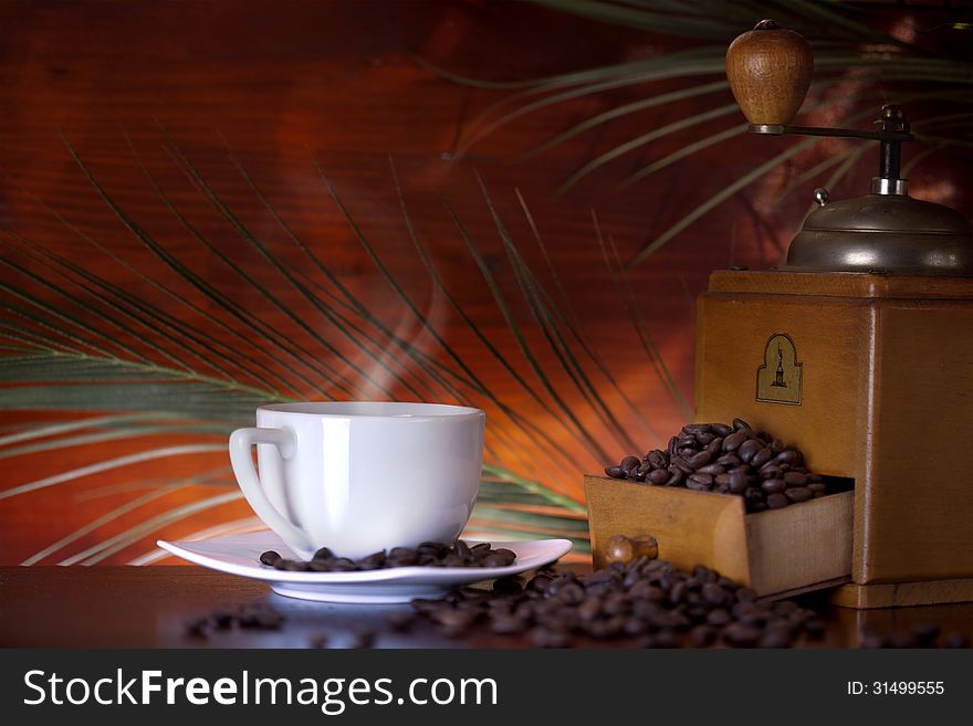 Cup of coffee with old grinder and coffee beans