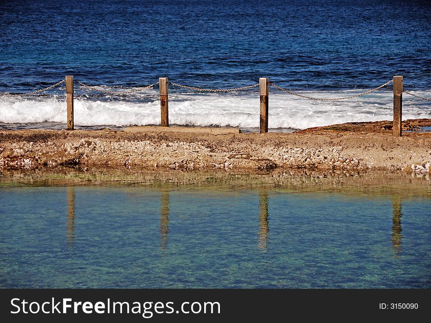 Reflection of posts and chains in an ocean pool. Reflection of posts and chains in an ocean pool