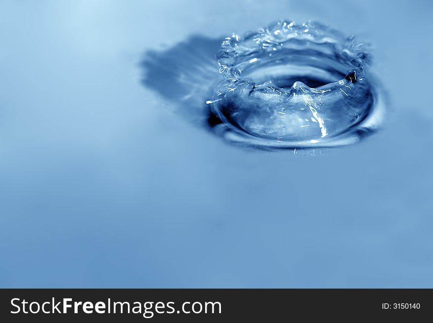 Blue drops are falling down and impact with liquid surface. Blue drops are falling down and impact with liquid surface