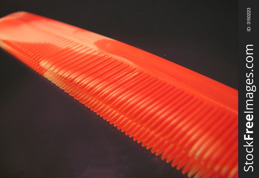 A red comb on the black background.