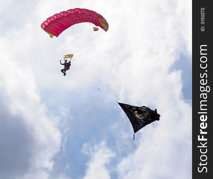 Parachutist with flag against a background of a blue sky