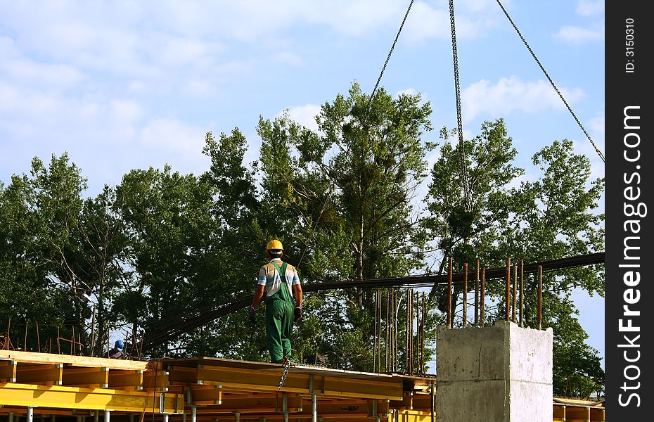 View at worker who is assisting at material transport on a ceiling. View at worker who is assisting at material transport on a ceiling