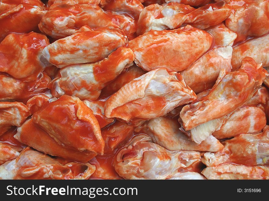Uncooked Chicken Wings covered in sause
