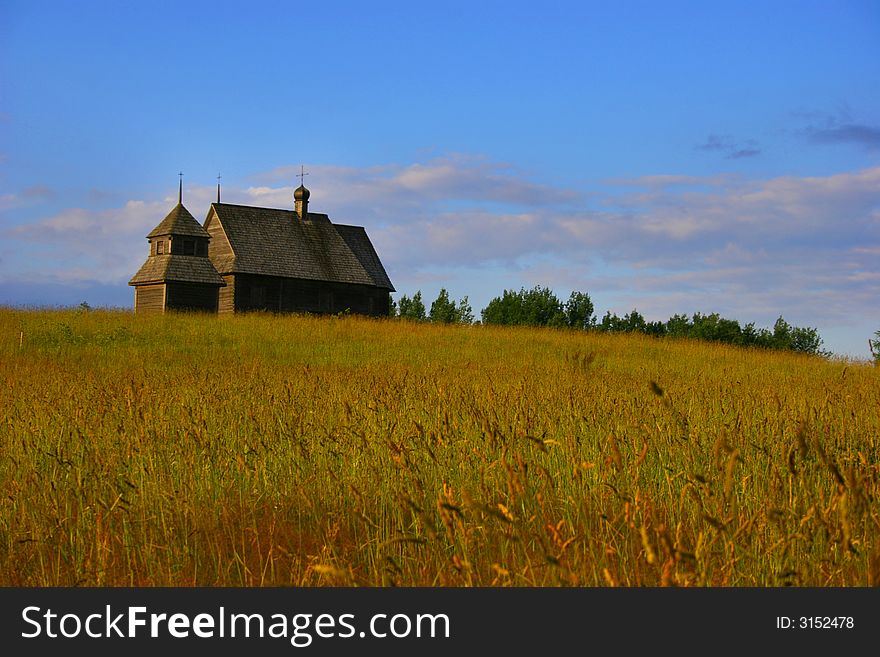 The old thrown house on a gold hill on a background of the dark blue sky