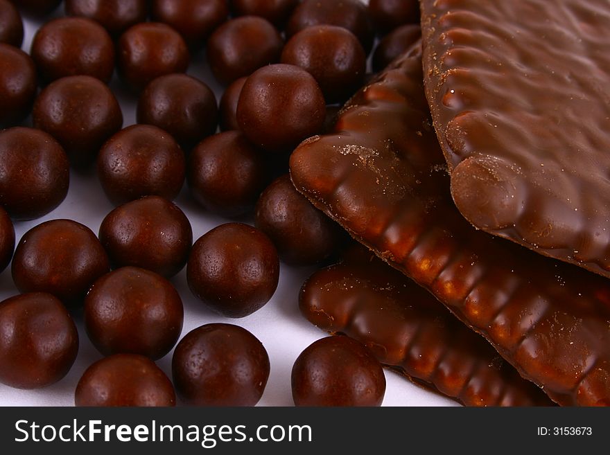 Black and brown chocolate sweets against white background