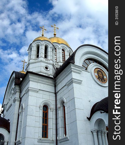 St.George church in Samara, Russia. Blue sky, clouds, golden domes and crosses. St.George church in Samara, Russia. Blue sky, clouds, golden domes and crosses.