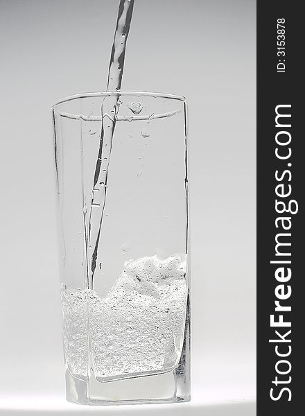 Jet of transparent water flowing in a glass and doing there water mixed with small bubbles. Jet of transparent water flowing in a glass and doing there water mixed with small bubbles