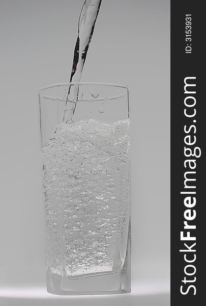 Jet of transparent water flowing in a glass and doing there water mixed with small bubbles. Jet of transparent water flowing in a glass and doing there water mixed with small bubbles