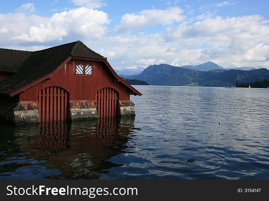 A boat house on Lake Lucerne.  Swiss Alps in the background.