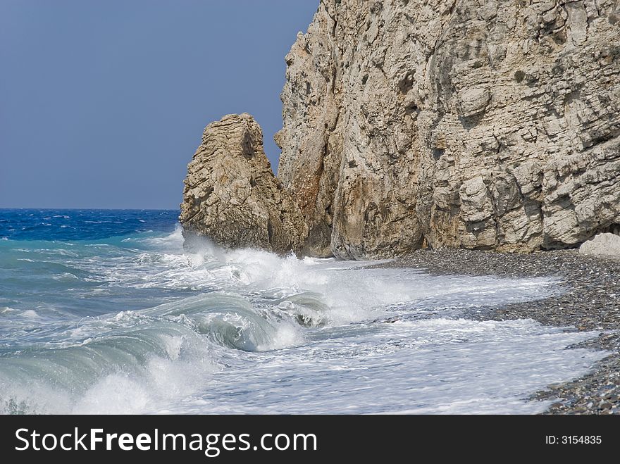 Wave breaking against rocks. Beach on the Samos Island, Greece.