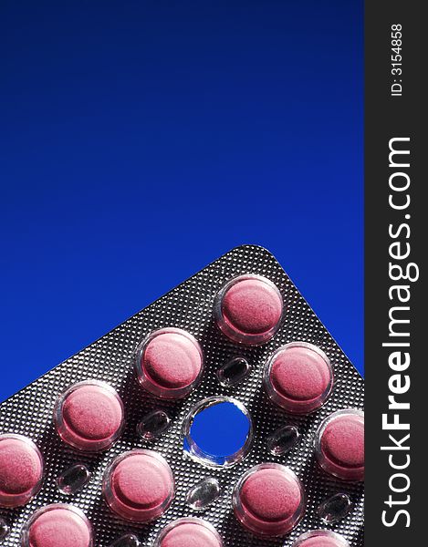 Packing of pink tablets on a dark blue background