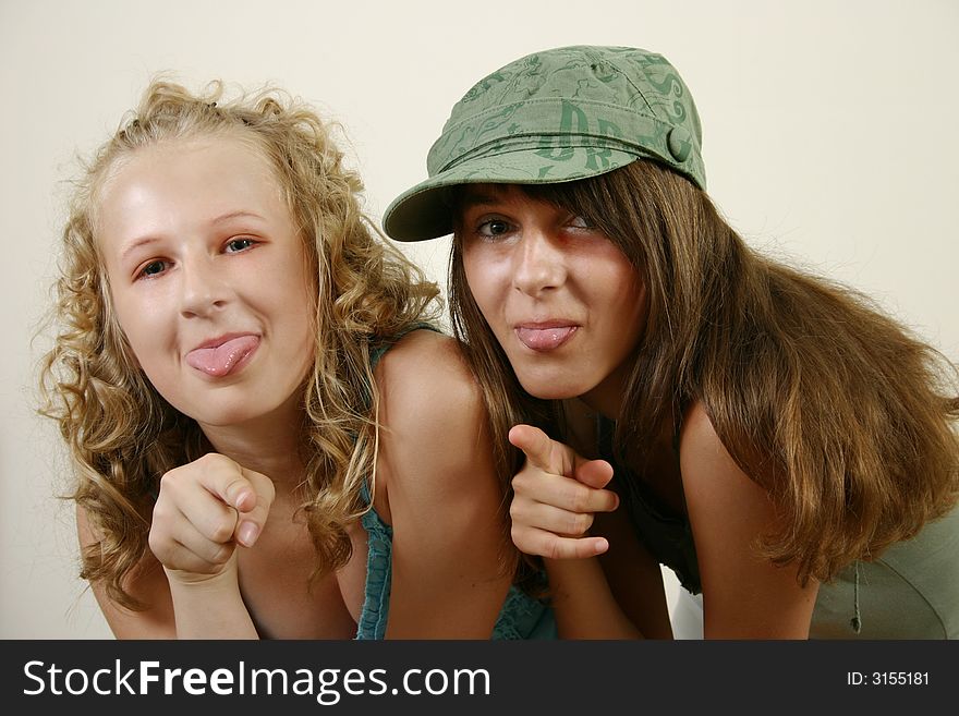 Portrait  of two young girls pokes out her tongue. Portrait  of two young girls pokes out her tongue